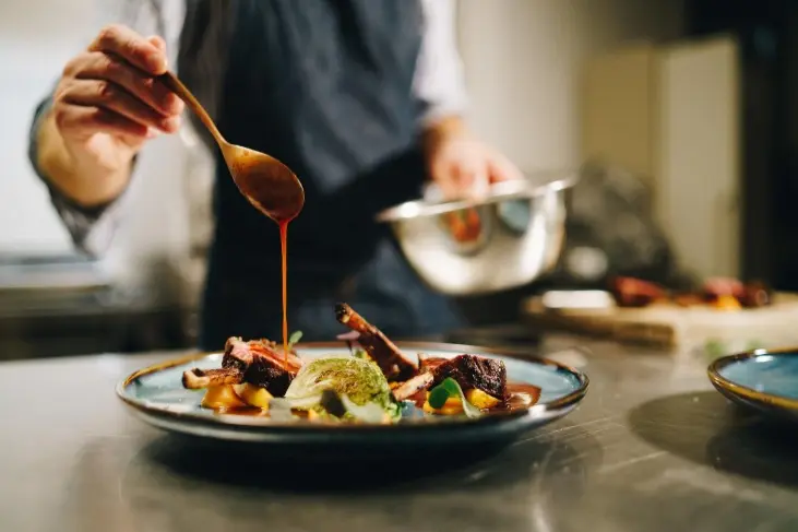 Servicio de hostelería - cocinero terminando su plato.