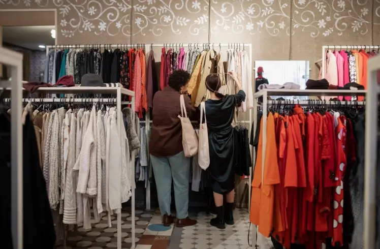 Mujeres mirando ropa en una tienda.